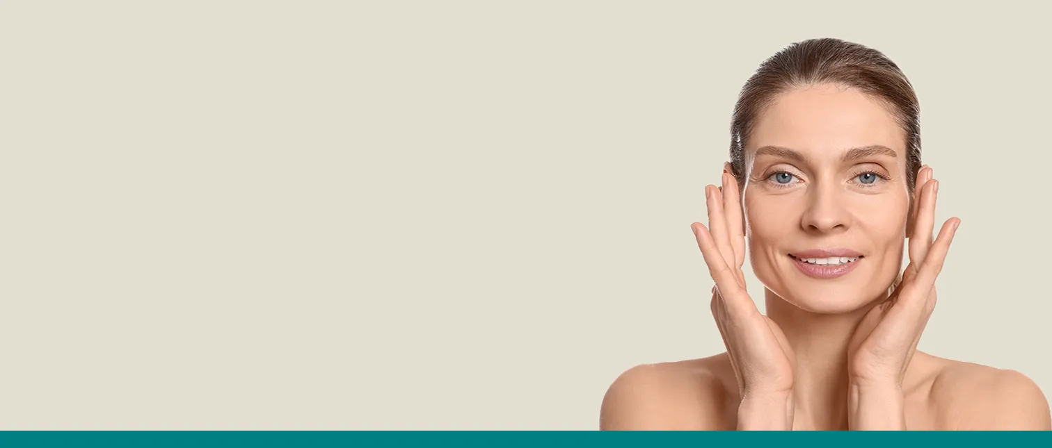 Vrouw raakt haar gezicht aan terwijl ze lacht – tips en advies over gezichtsvormen van Merz Aesthetics