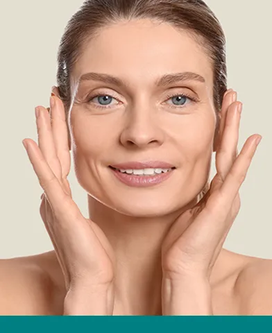 Vrouw raakt haar gezicht aan terwijl ze lacht – tips en advies over gezichtsvormen van Merz Aesthetics