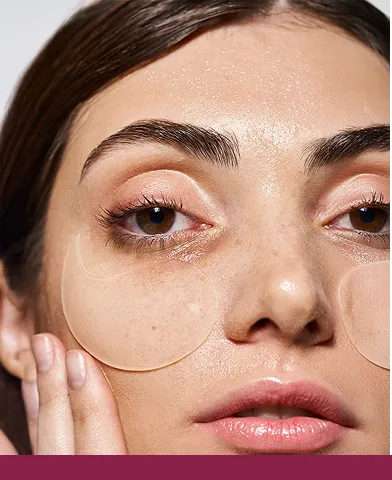 Een vrouw met zichtbare donkere traangoot en een verfrissend oogmasker op haar gezicht.