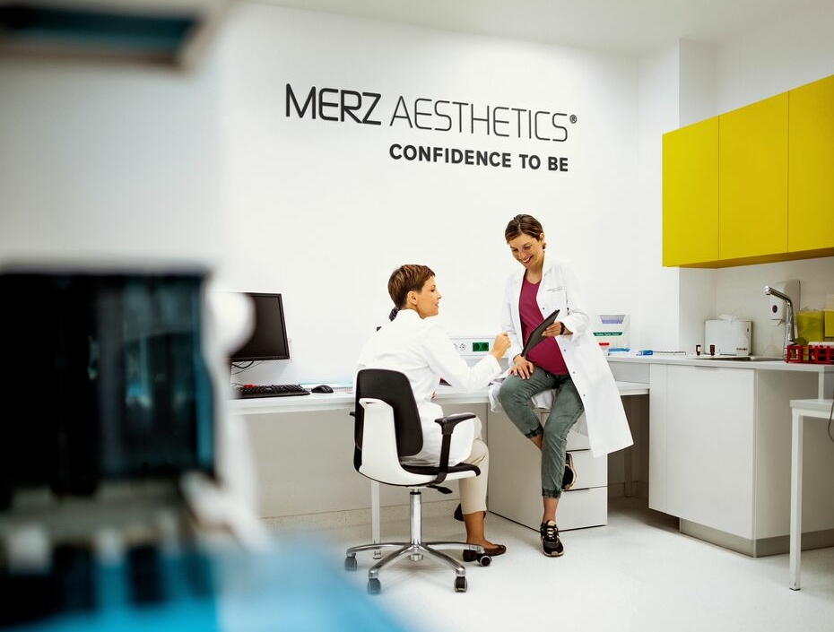 Onderzoekers in een laboratorium van Merz Aesthetics bespreken innovatie in medische esthetiek.