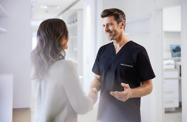 Een arts schudt de hand van een patiënte