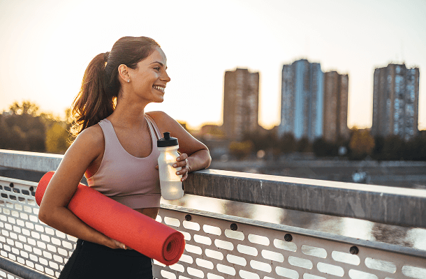 Sportieve volwassene met sportmat en waterfles